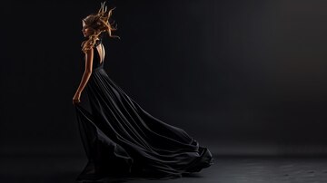 woman black dress with flowing fabric poses against dark background 14117 654907